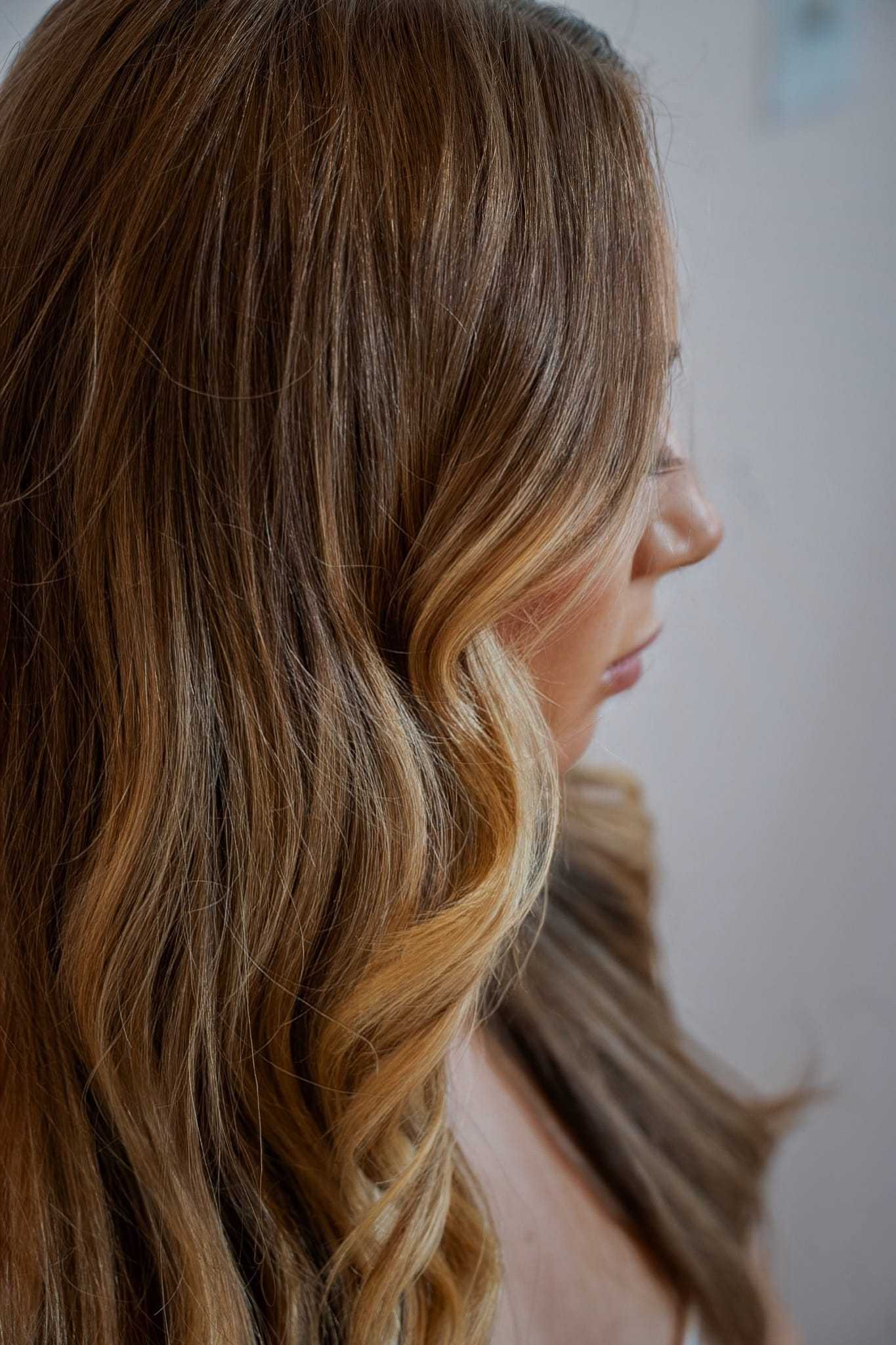 Wavy-haired person in profile with blonde highlights.