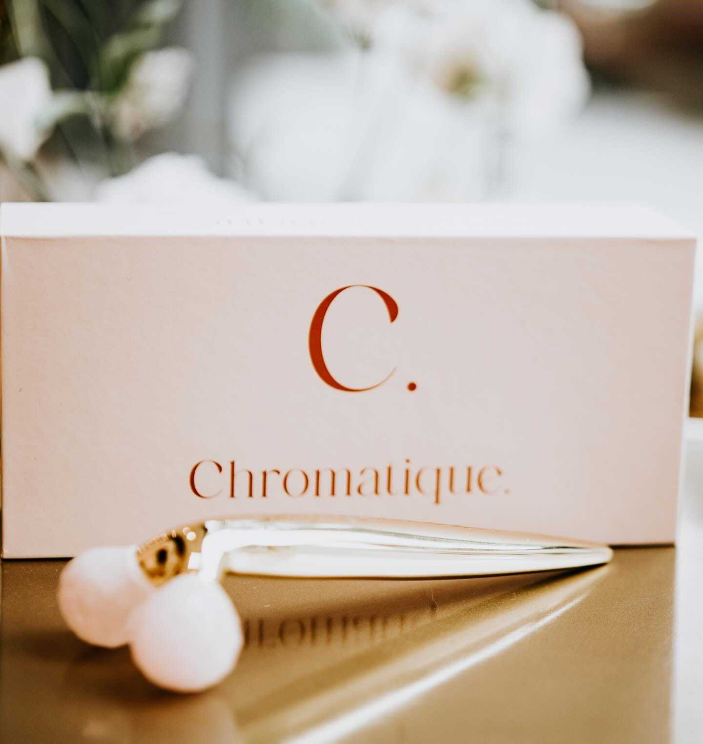 Elegant packaging of Chromatique skincare with a facial massage tool in front.